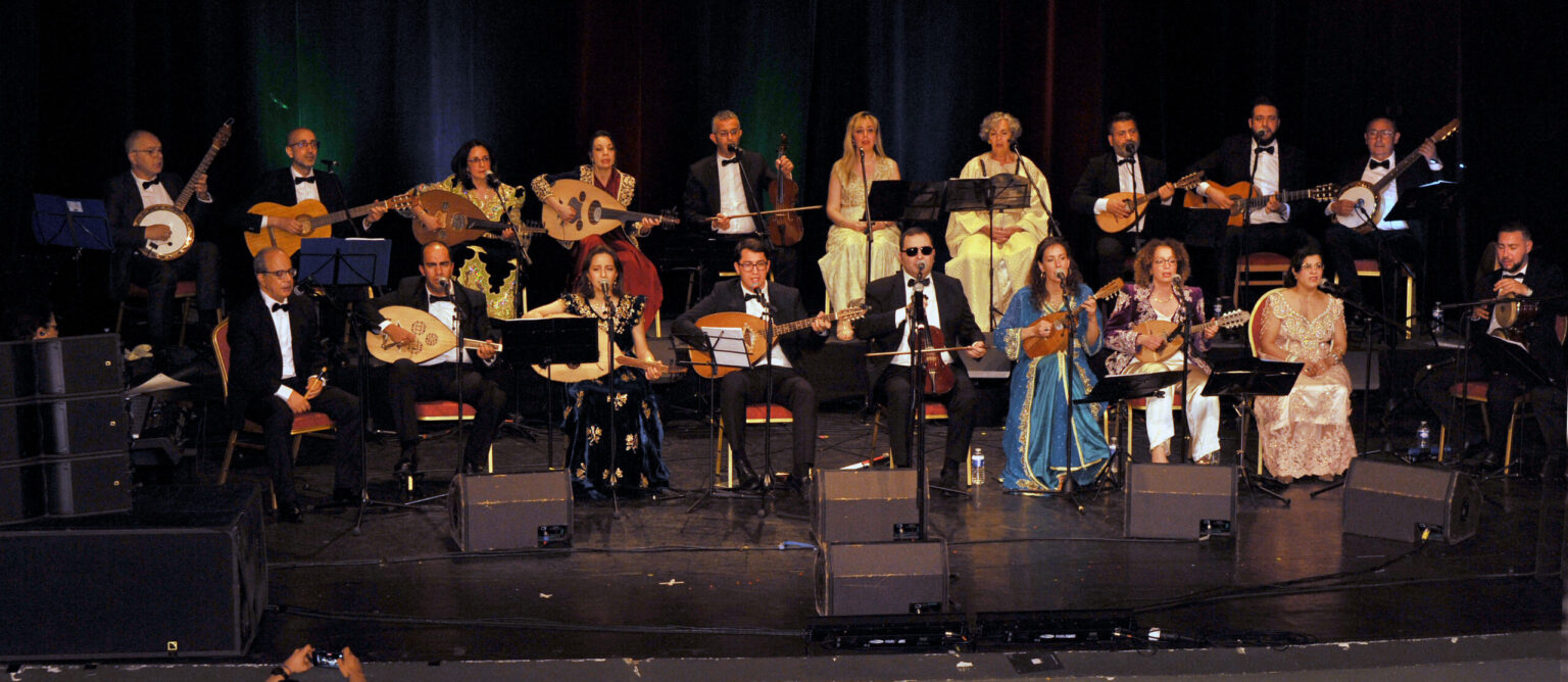 SABA Orchestra en tenues de scène lors du concert de ses dix ans, musiciens et chanteurs réunis en deux rangées.